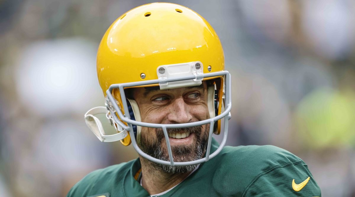 Aaron Rodgers smiles while warming up for the Packers